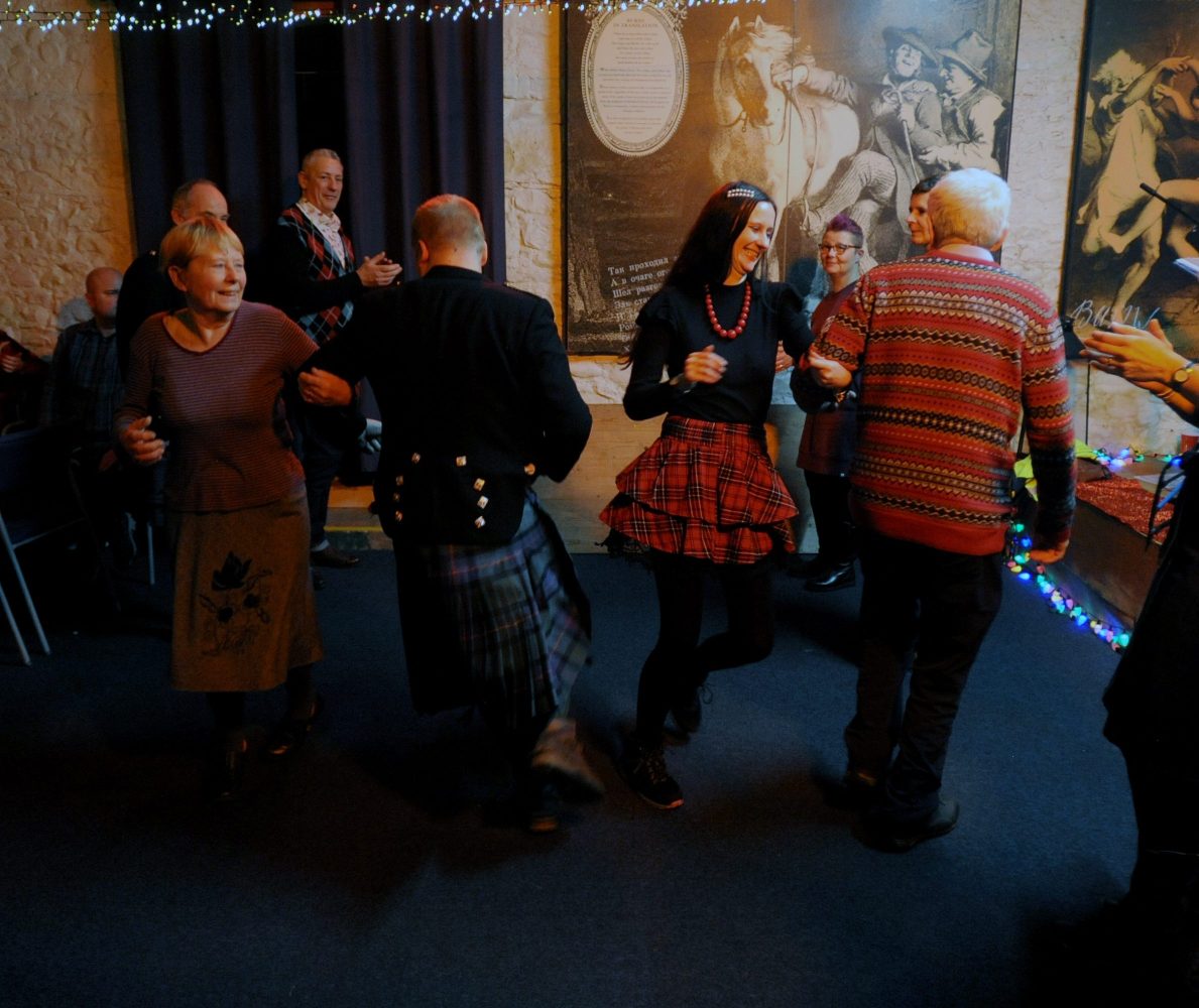 Guests dancing Strip the Willow at the Hogmanay party.